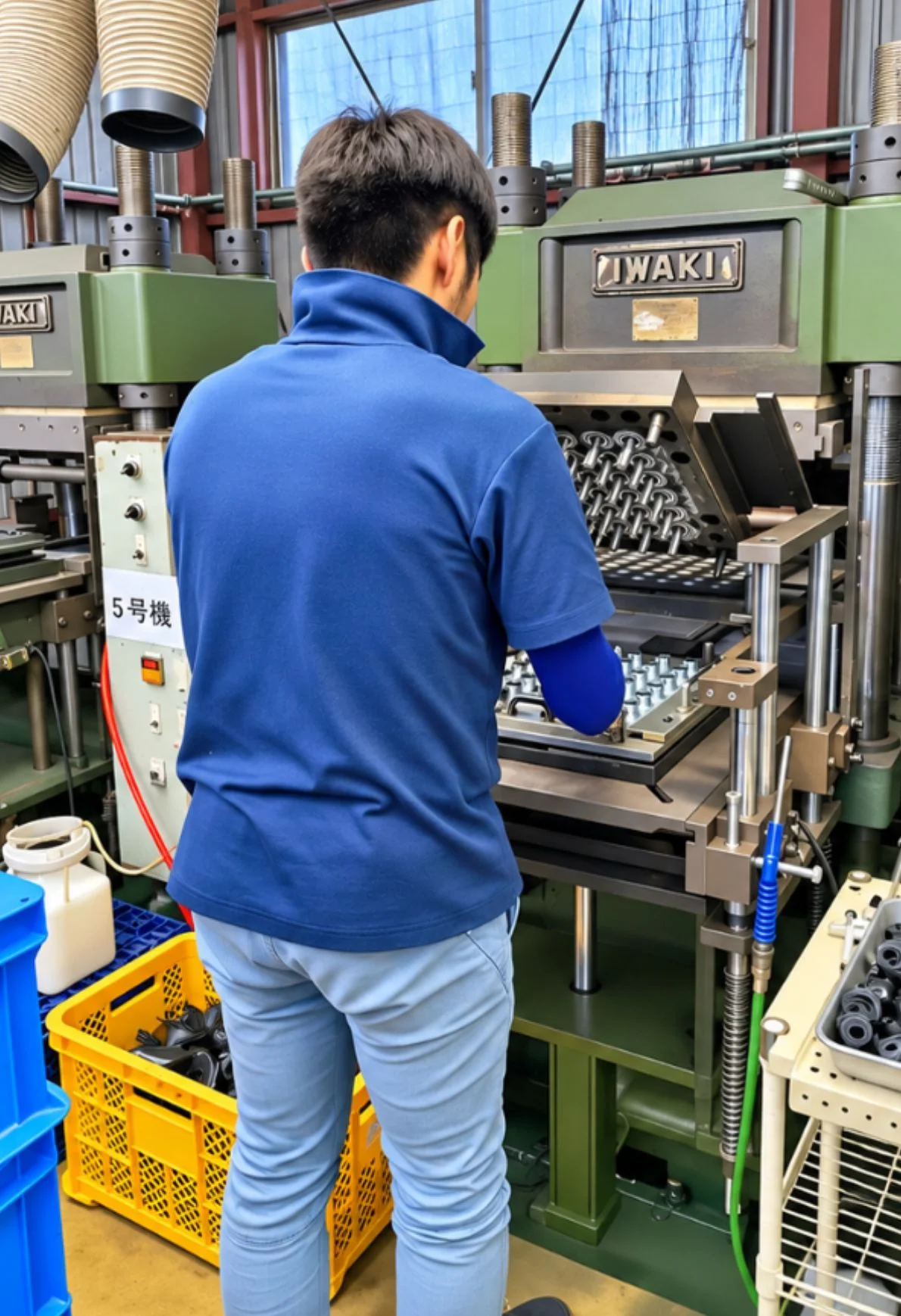 IWAKIプレス機でゴム成形品の作業をする作業者